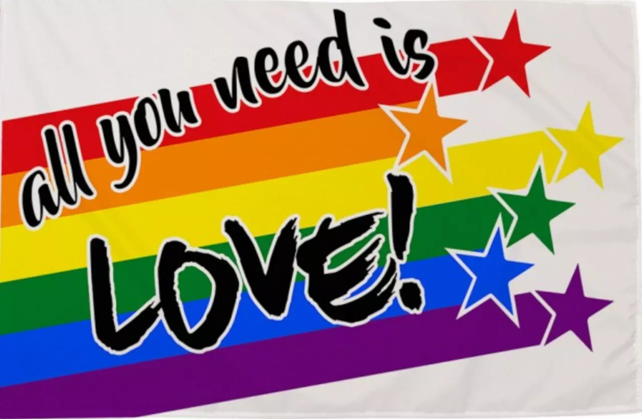 Die 'All You Need is Love' Regenbogenflagge, ein lebendiges Symbol der LGBTQ+-Gemeinschaft, das Liebe und Akzeptanz betont. Diese Flagge zeichnet sich durch ihre leuchtenden Regenbogenfarben aus, die für Vielfalt und Inklusion stehen. Im Zentrum prangt de