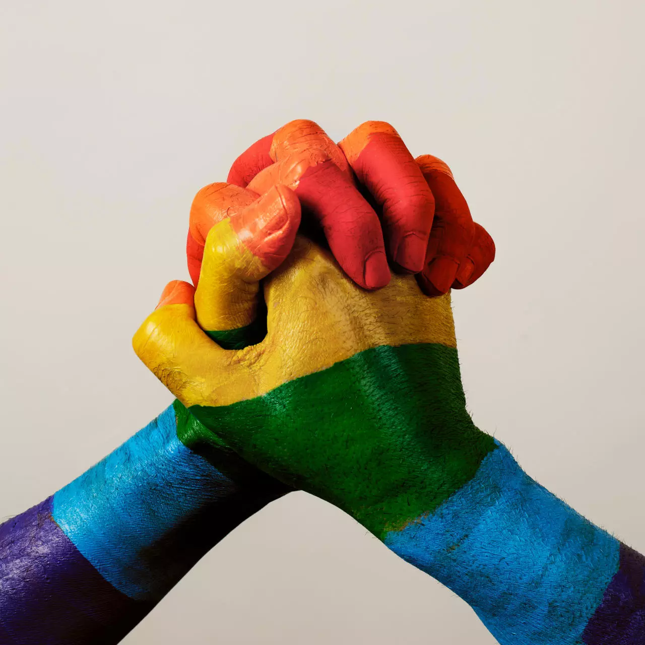 Zwei Hände, von unten gesehen, sind in den Farben des Regenbogens bemalt und zu einer Faust vereint, symbolisieren Solidarität und Unterstützung, eine ausdrucksstarke Botschaft von flaggenmeer