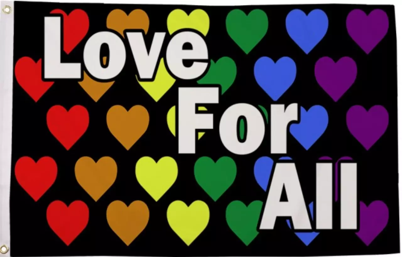 Die 'Love for All' Flagge mit einem schwarzen Hintergrund, verziert mit zahlreichen kleinen Herzen in Regenbogenfarben. Diese Herzen sind in Reihen angeordnet, wobei jede Reihe aus fünf Herzen in der gleichen Regenbogenfarbe besteht, was eine harmonische 